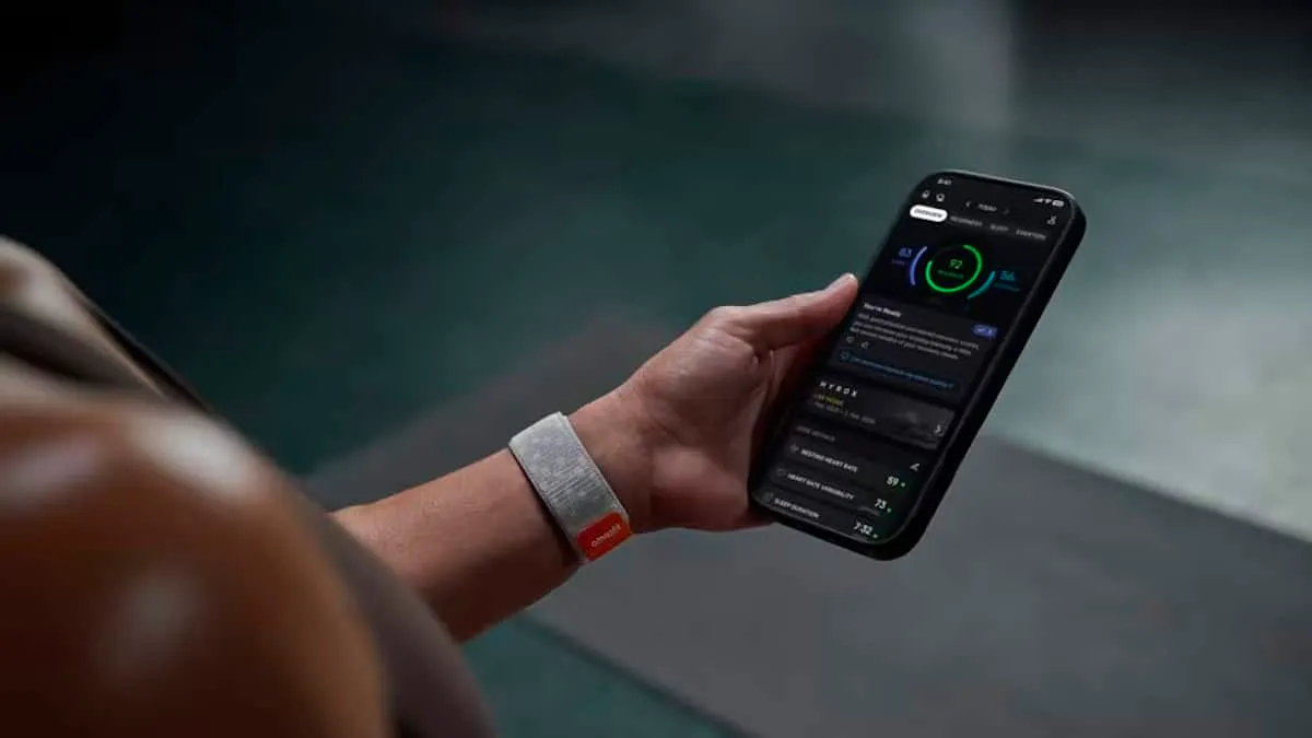Persona con el Amazfit Helio Strap en la muñeca mientras consulta la aplicación en el teléfono